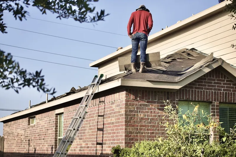 Professional roofer working on a residential roof in Foulkeways